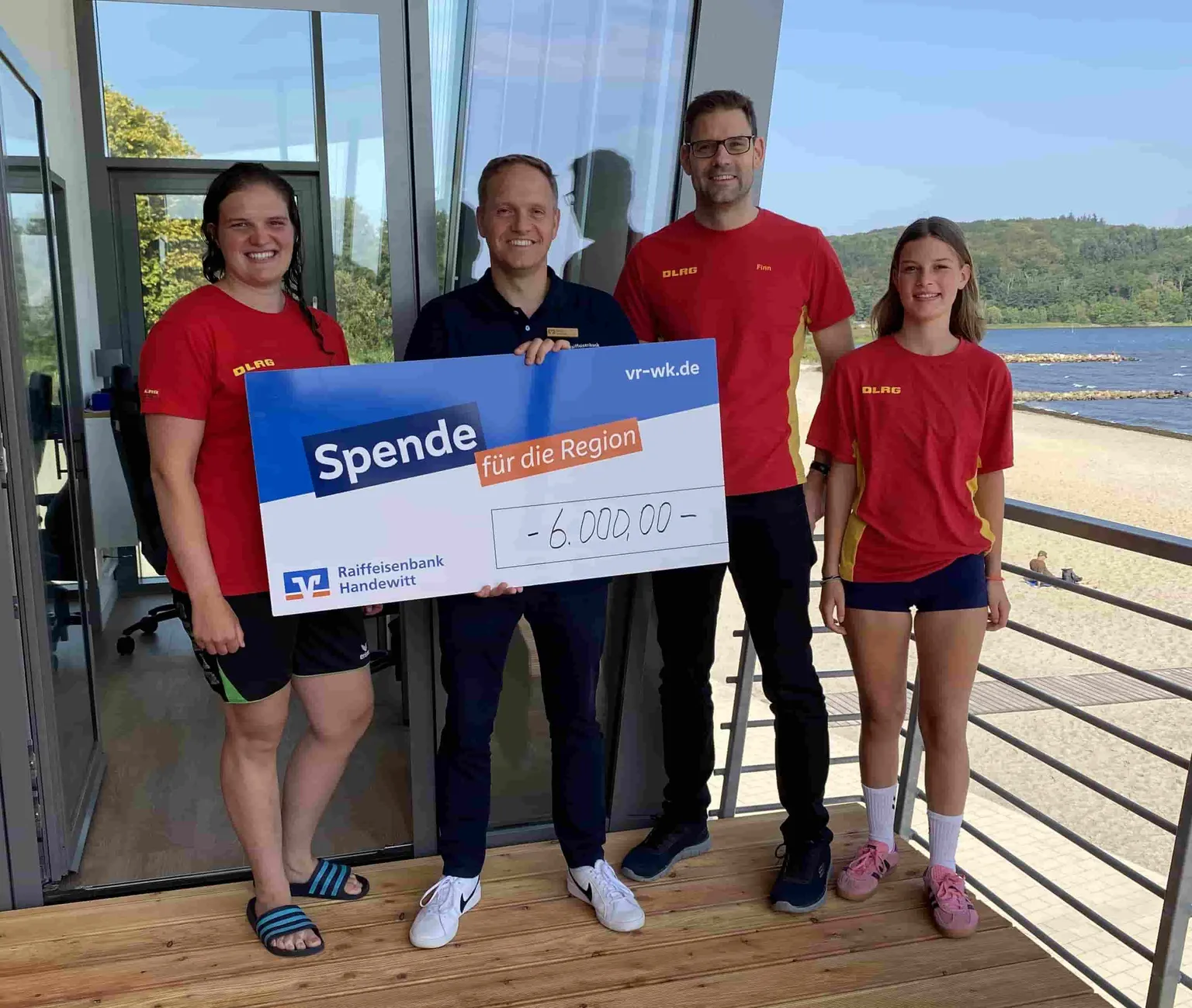 Spenden für die DLRG Harrislee e. - Vier Personen mit Spendencheck